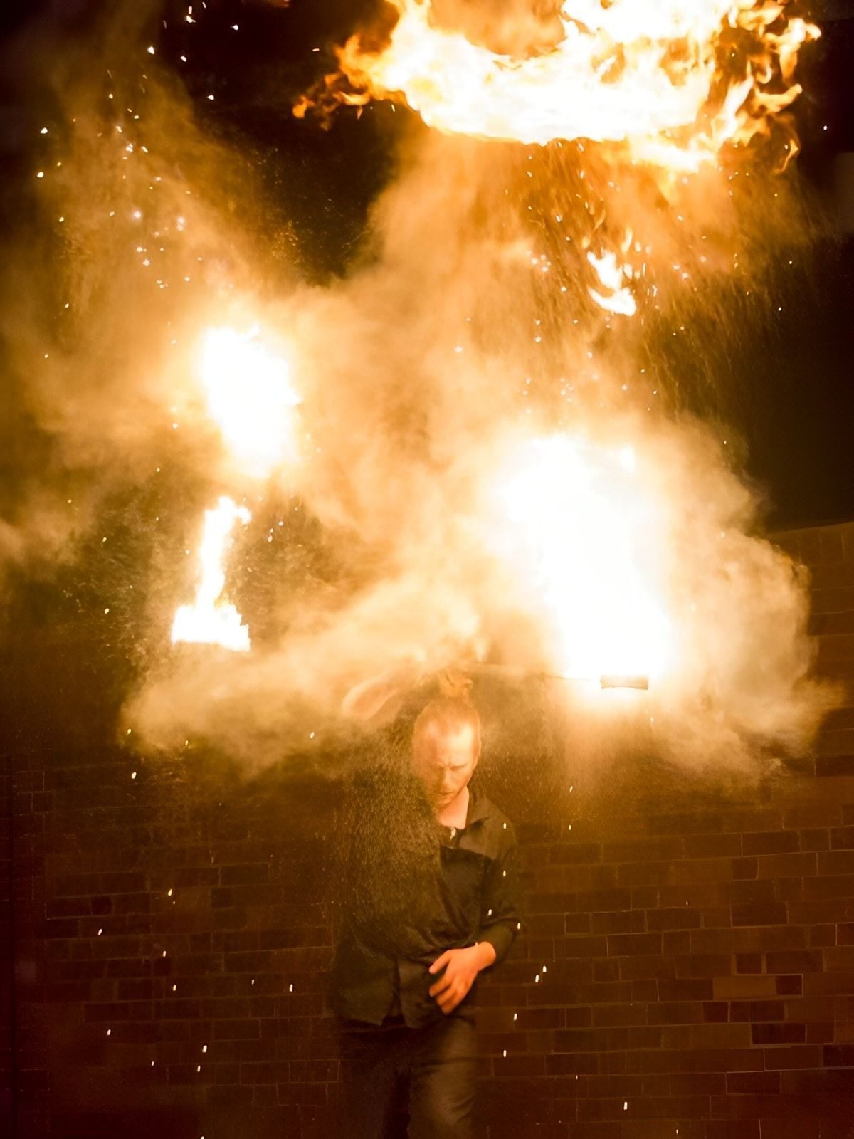 Eldshow - eldartist med eldstav i eldmoln