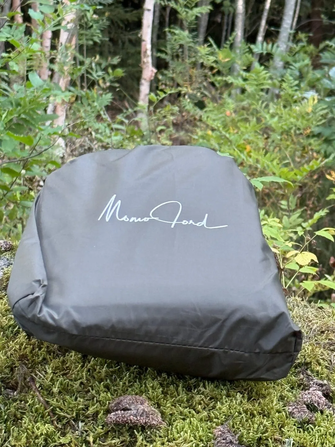 Packpåse till vintertarp liggande på mossa i skogen