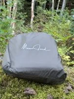 Vintertarpens packpåse på mossa Packpåse till vintertarp liggande på mossa i skogen